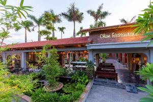 un restaurant avec des tables, des chaises et des palmiers dans l'établissement Tam Coc Banana Bungalow, à Ninh Binh