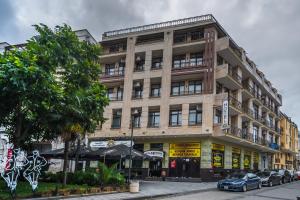 duży budynek z samochodami zaparkowanymi przed nim w obiekcie Old Garden Hotel Batumi w mieście Batumi