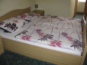 a bed with a bedspread with flowers on it at Hotel Kilian in Braunlage +30 photos