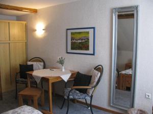 Zimmer mit einem Tisch, Stühlen und einem Spiegel in der Unterkunft Hotel Kilian in Braunlage