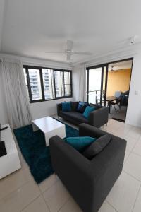 uma sala de estar com um sofá e uma mesa em WATERFRONT DARWIN TROPICAL GEM em Darwin