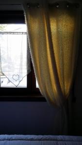 una ventana con una cortina amarilla en un dormitorio en Chalet Plein Sud, en Montgenèvre