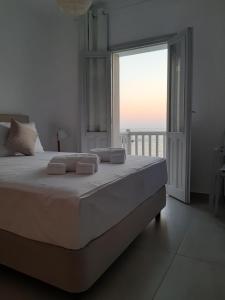 a bedroom with a large bed with a large window at en lefko in Lefkos Karpathou