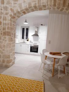 a kitchen and dining room with a table and chairs at en lefko in Lefkos Karpathou
