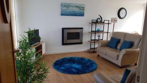 a living room with a couch and a blue rug at Ynys Lawd, Holyhead Marina in Holyhead