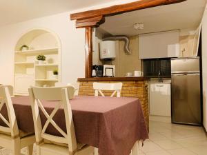 a kitchen with a table with chairs and a refrigerator at Pancrazio in Taormina