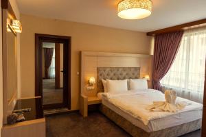 a bedroom with a large bed and a large window at Boutique hotel Provence Бутик хотел Прованс in Petrich