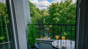 dwa kieliszki wina siedzące na stole na balkonie w obiekcie Rent like home - Słoneczna 3 w Zakopanem