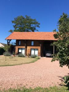 a house with a red roof on a gravel yard at La Grange de l’Ouche in Saint-Parize-le-Châtel