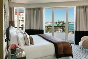 a bedroom with a bed with a view of the ocean at Hôtel Barrière Le Majestic Cannes in Cannes