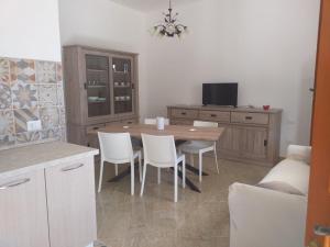 cocina con mesa, sillas y sofá en casa La Mimosa, en Castelluzzo
