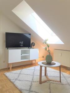 een woonkamer met een tv en een tafel bij Zwillingsperlen Leutzsch – Appartement Reiterhof in Leipzig