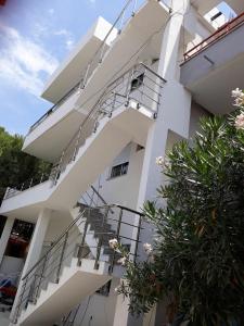 a white building with a spiral staircase on it at Blue Coral apartament in Velipojë