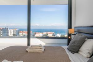 The Villa / Ericeirahills في إيريسييرا: غرفة نوم مع سرير وإطلالة على المحيط