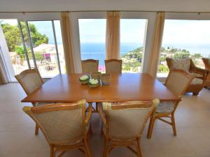 a dining room with a wooden table and chairs at Casa Mahler in Jávea
