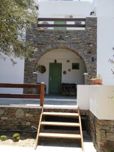 un arco de ladrillo que conduce a una puerta con una escalera en Madilides en Platis Yialos Sifnos