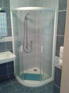 La salle de bains est pourvue d'une douche avec une porte en verre. dans l'établissement Apartmán Anežka, à Luhačovice