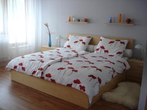 Un dormitorio con una cama con flores rojas. en Apartmán Anežka, en Luhačovice