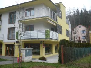 a yellow and white building with a balcony at Apartmán Anežka in Luhačovice