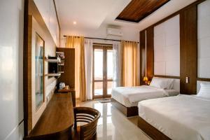 ペニダ島にあるNusa Sedayu Hotel By Ocean Viewのベッド2台と窓が備わるホテルルームです。