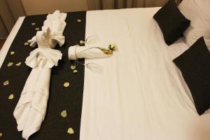 Una cama con un vestido blanco y una pajarita negra en Hotel Rural Molino del Albaicín en Sabiote