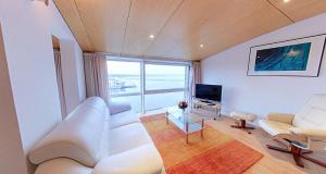 a living room with white furniture and a large window at Speicher Barth - Superior-Hotel in Barth