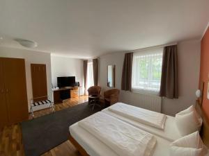 a bedroom with a large white bed and a living room at OG's Golf Lodge in Kematen an der Krems