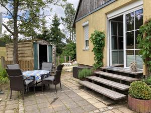a patio with a table and chairs next to a house at an der Liesel Wiese in Johanngeorgenstadt