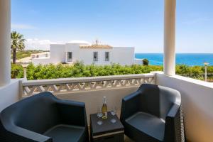 einen Balkon mit einem Tisch, Stühlen und Meerblick in der Unterkunft Terraços de Benagil 23 (Casa Alvorada) in Benagil