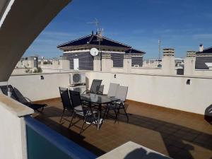 a balcony with a table and chairs on a roof at Playamarina 2 Cabo Roig in Playas de Orihuela