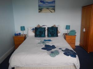 a bedroom with a white bed with blue pillows at Rob Roy Guest House in Folkestone