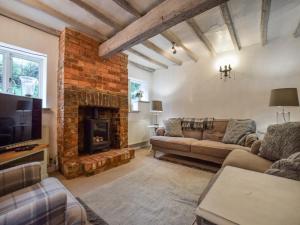 a living room with a couch and a fireplace at Suncroft in Shotteswell