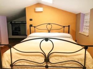 un letto in una camera da letto con parete gialla di Casa 'Zia Lucia' in Demetra Village, Policoro a Policoro