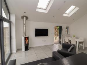 a living room with a fireplace and a tv at Cartrefle Fach in Pentraeth