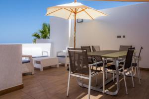 ein Esszimmer mit einem Tisch und einem Sonnenschirm in der Unterkunft Can Binitu in Capdepera
