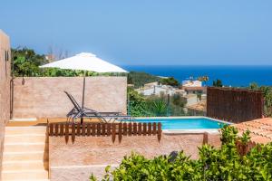eine Villa mit Swimmingpool und Sonnenschirm in der Unterkunft Can Binitu in Capdepera