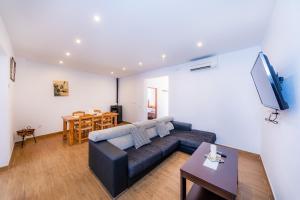 ein Wohnzimmer mit einer Couch und einem Tisch in der Unterkunft Can Binitu in Capdepera