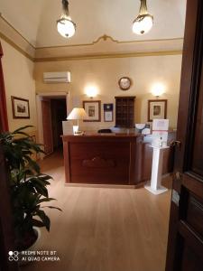 una oficina con un escritorio y un reloj en la pared en Catania Centro Rooms, en Catania