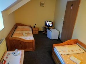 Hlučín的住宿－Restaurant-Penzión HEVIL，一间设有两张床和电视的房间