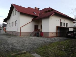 une grande maison blanche avec un toit rouge dans l'établissement Restaurant-Penzión HEVIL, à Hlučín