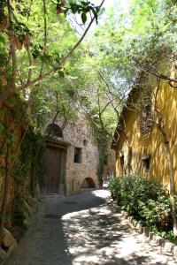 un callejón con un edificio de piedra y una calle arbolada en Hotel Esplugues en Esplugues de Llobregat