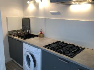 eine Küche mit einem Herd und einer Waschmaschine in der Unterkunft Les Appartements Chambon in Sarlat-la-Canéda