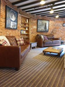 a living room with leather couches and a brick wall at The Windmill in Scarborough