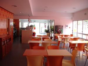 une salle à manger avec des tables et des chaises dans un restaurant dans l'établissement Parque De Campismo Orbitur Gala, à Figueira da Foz