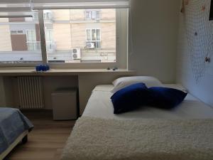 a bed with blue pillows in a room with a window at RosAmar in Bari