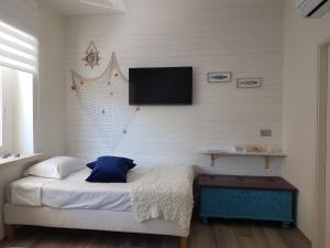 a bedroom with a bed with a tv on the wall at RosAmar in Bari