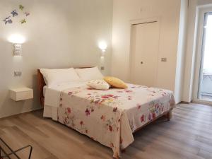 a bedroom with a bed with a floral blanket on it at RosAmar in Bari