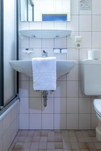 Gasthaus zum Ochsen في Herrischried: حمام مع حوض أبيض ومرحاض