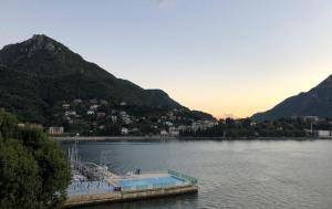a dock in the middle of a lake with mountains at Hotel Alberi in Lecco