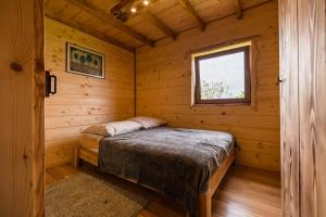 a bedroom with a bed in a log cabin at Chaty Jak Dawniej in Wołkowyja